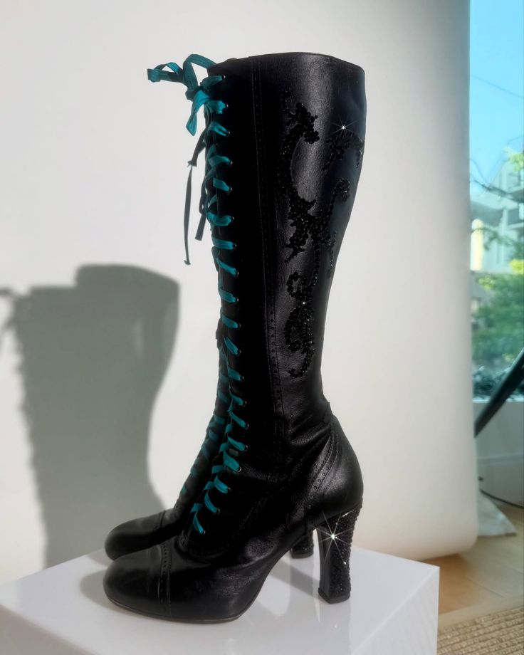 Tall black leather lace-up boot with a high heel and decorative stitching