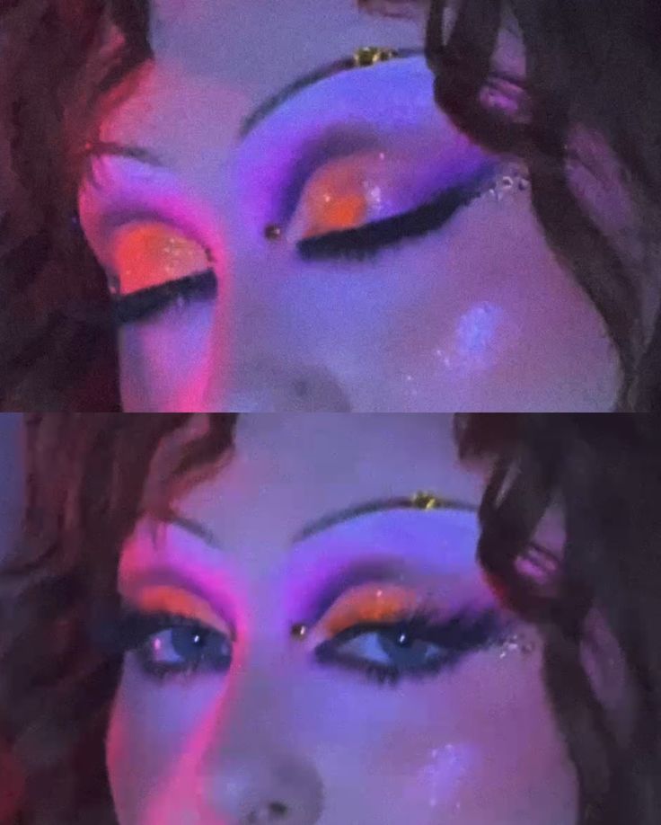 Close-up of a person with eyes closed wearing bright orange eyeshadow, long false eyelashes, and decorative rhinestones near the eyes