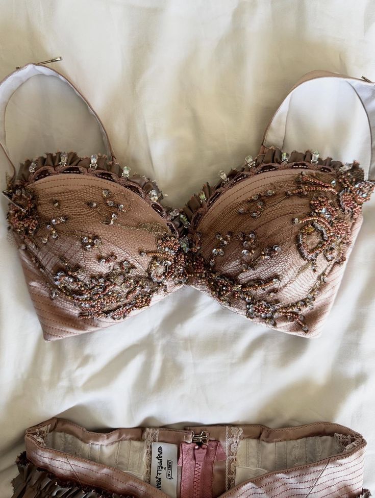 Beige bra with floral embroidery and bead embellishments on a white fabric background
